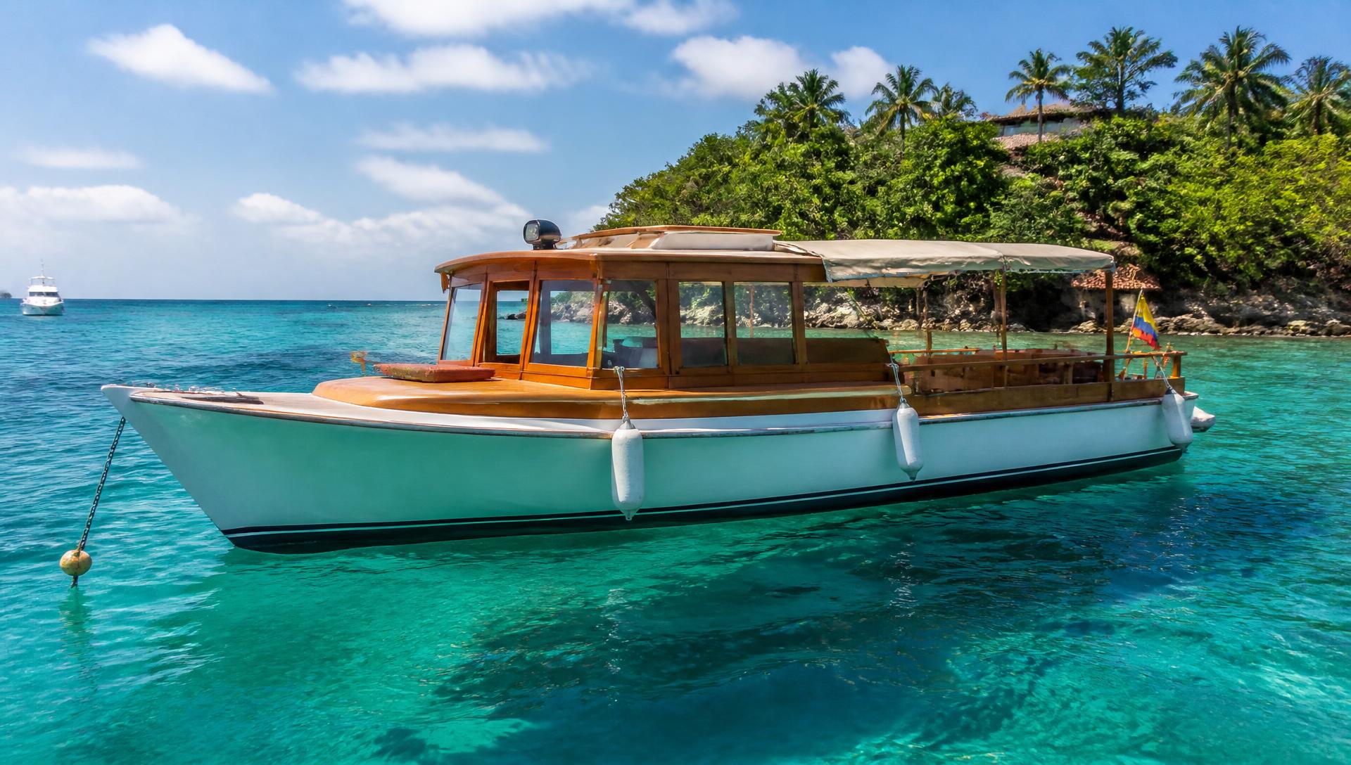 Wooden luxury boat anchored in turquoise water near the Rosario Islands