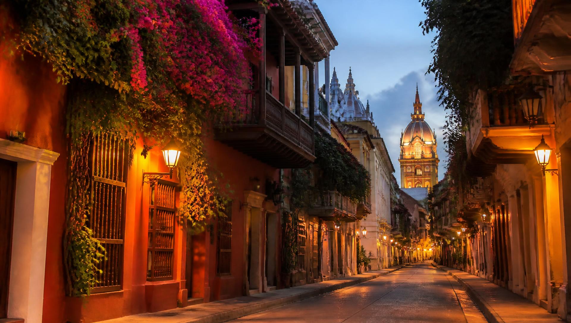 Colonial street in Cartagena old town lit by lanterns at dusk
