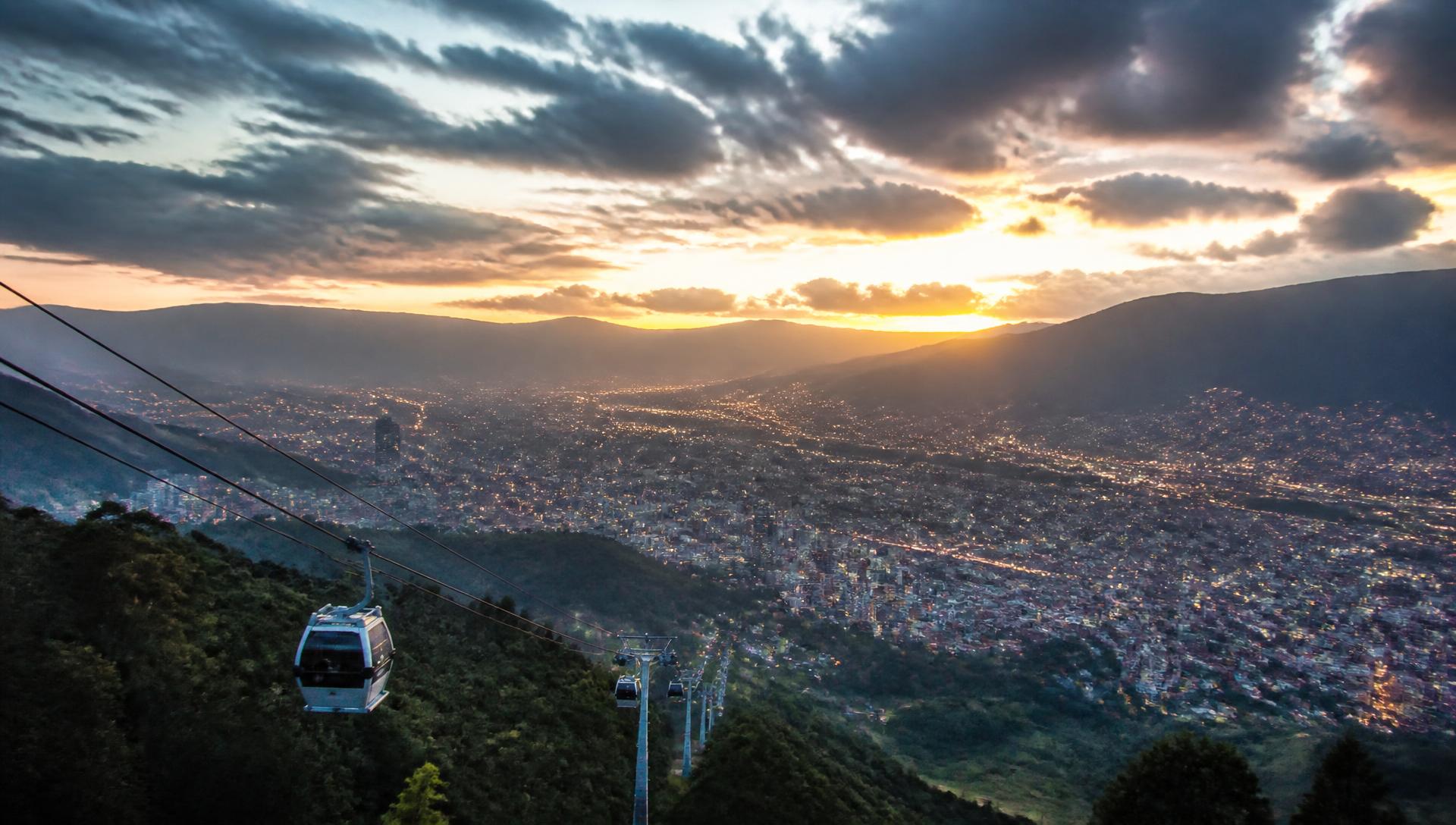 Cable car above Medellín with the valley lit up at sunset